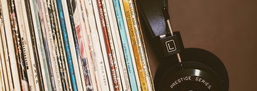 Black headphones lean against a row of record cases.